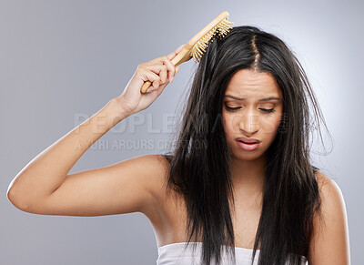 Buy stock photo Hair, knot and woman with brush in studio with worry for split ends, haircare crisis and messy style. Beauty, hairdresser and female person with frizz, texture and tangle problem on gray background