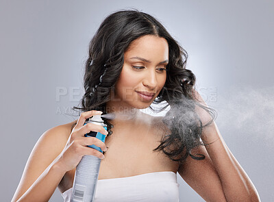 Buy stock photo Shot of a woman putting hairspray on her hair