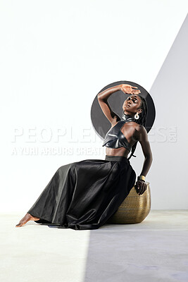 Buy stock photo Shot of an attractive young woman posing in a black outfit against a wall with a circle on it