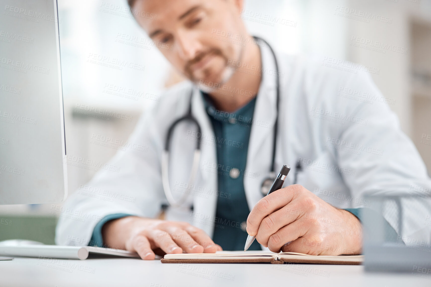 Buy stock photo Closeup shot of a mature doctor writing notes in a medical office