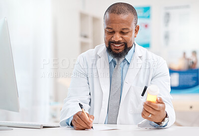 Buy stock photo Shot of a mature doctor writing notes while holding a bottle of tablets in a medical office