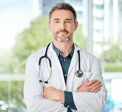 Buy stock photo Shot of a medical practitioner standing with his arms crossed in a hospital