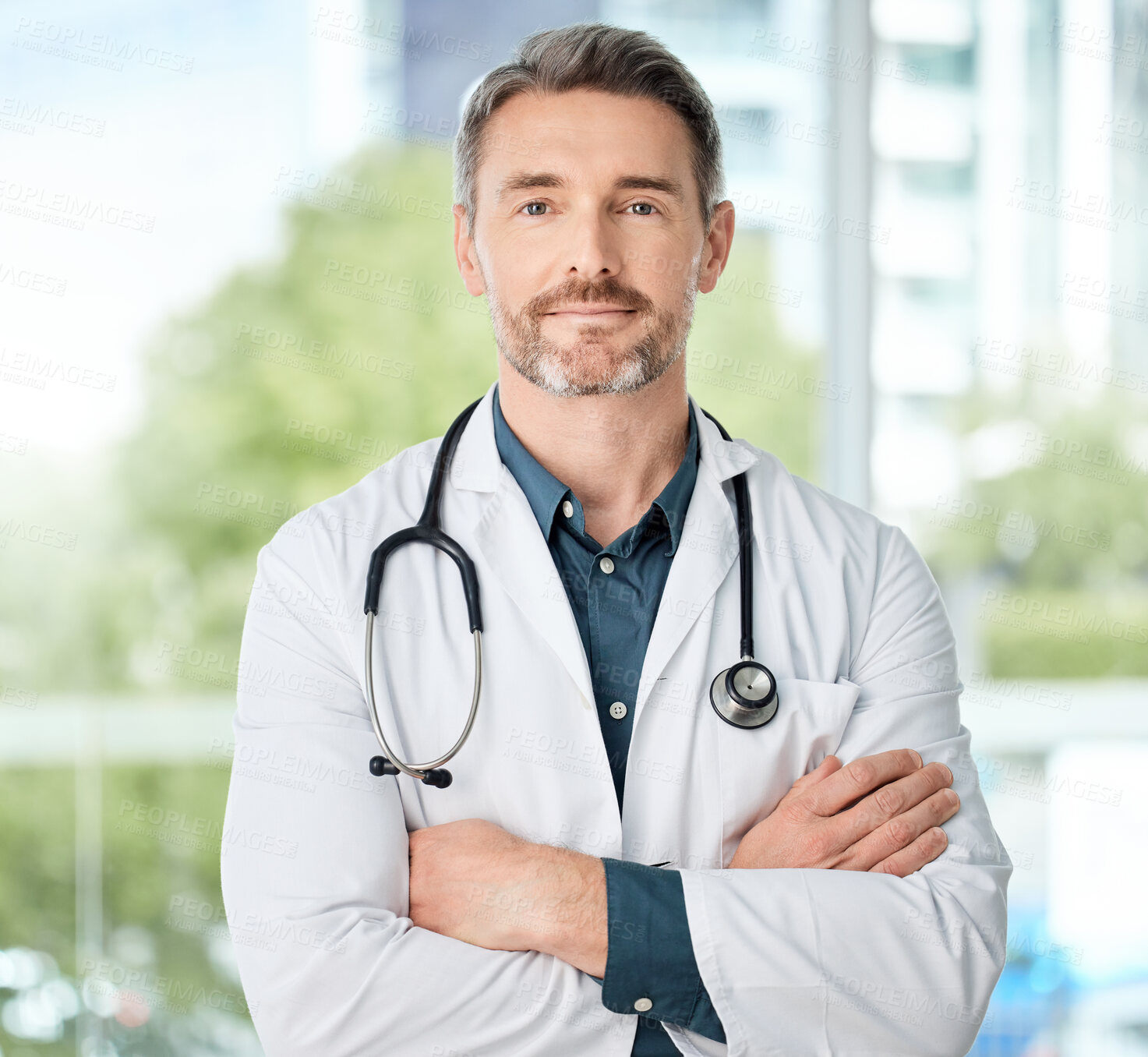 Buy stock photo Shot of a medical practitioner standing with his arms crossed in a hospital