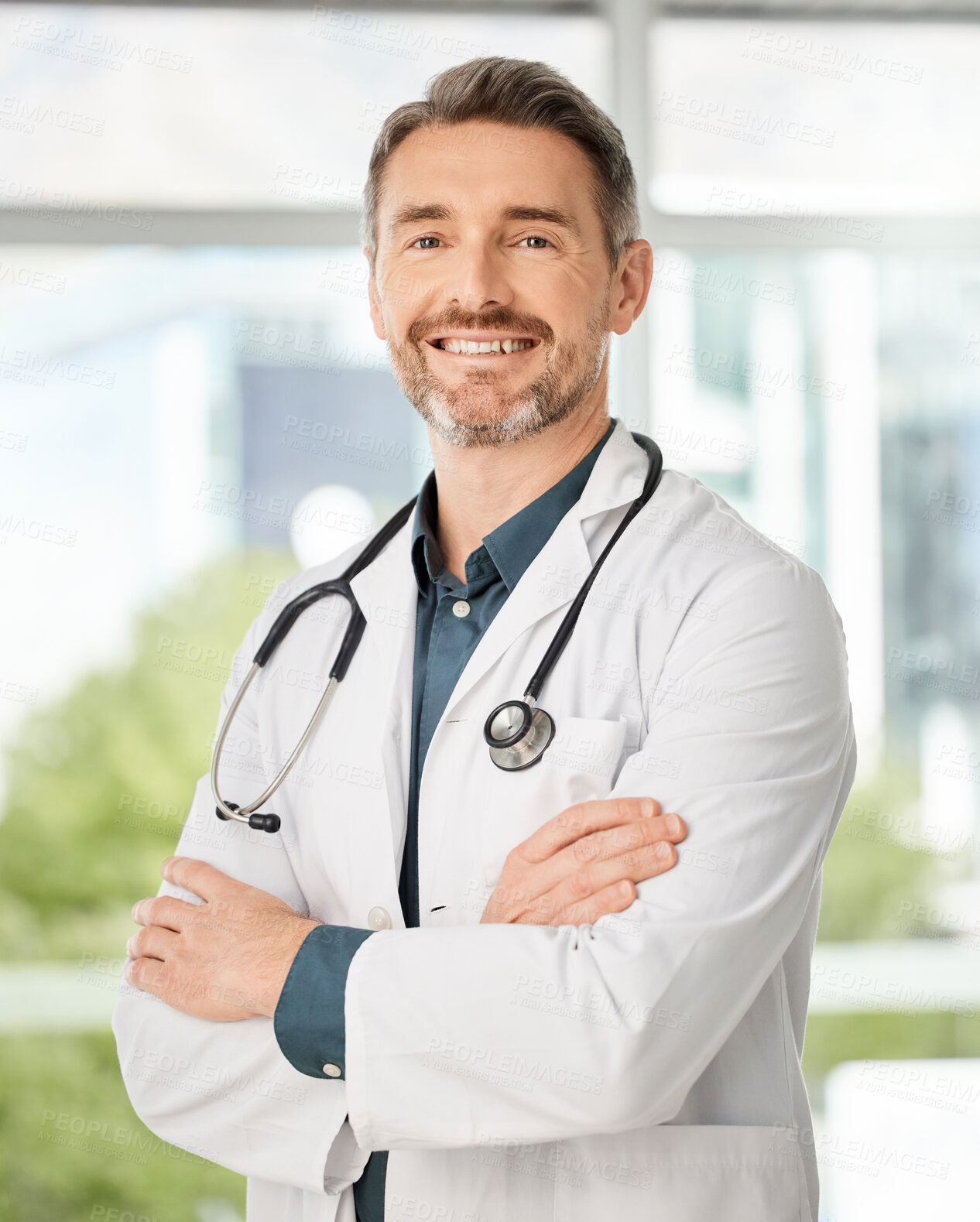 Buy stock photo Shot of a medical practitioner standing with his arms crossed in a hospital