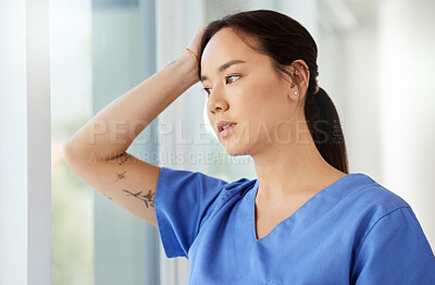 Buy stock photo Shot of a female nurse looking stressed while standing in a hospital