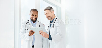 Buy stock photo Shot of two mature doctors using a tablet in a office