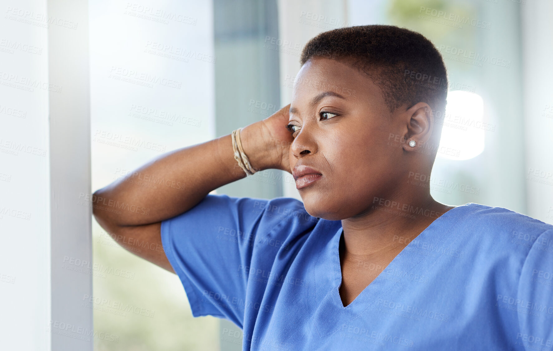 Buy stock photo Shot of a female nurse looking stressed while standing in a hospital