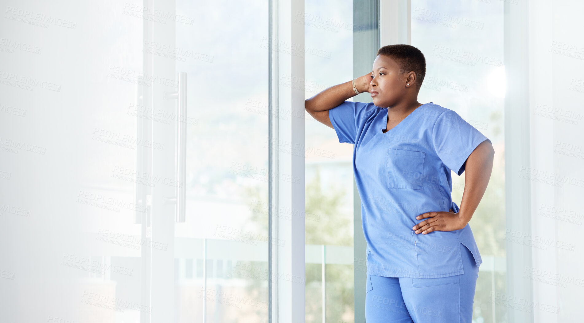 Buy stock photo Shot of a female nurse looking stressed while standing in a hospital