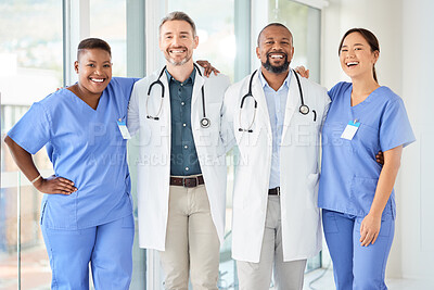 Buy stock photo Shot of a cheerful group of doctors standing with their arms around each other inside of a hospital during the day