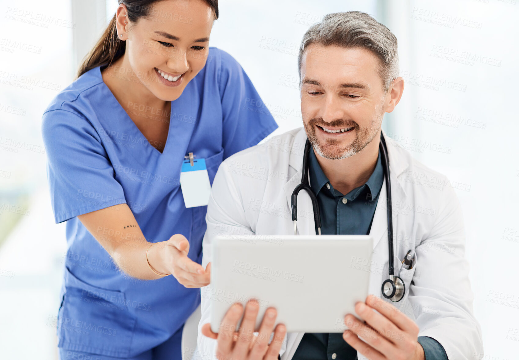 Buy stock photo Shot of two doctors using a tablet in a office