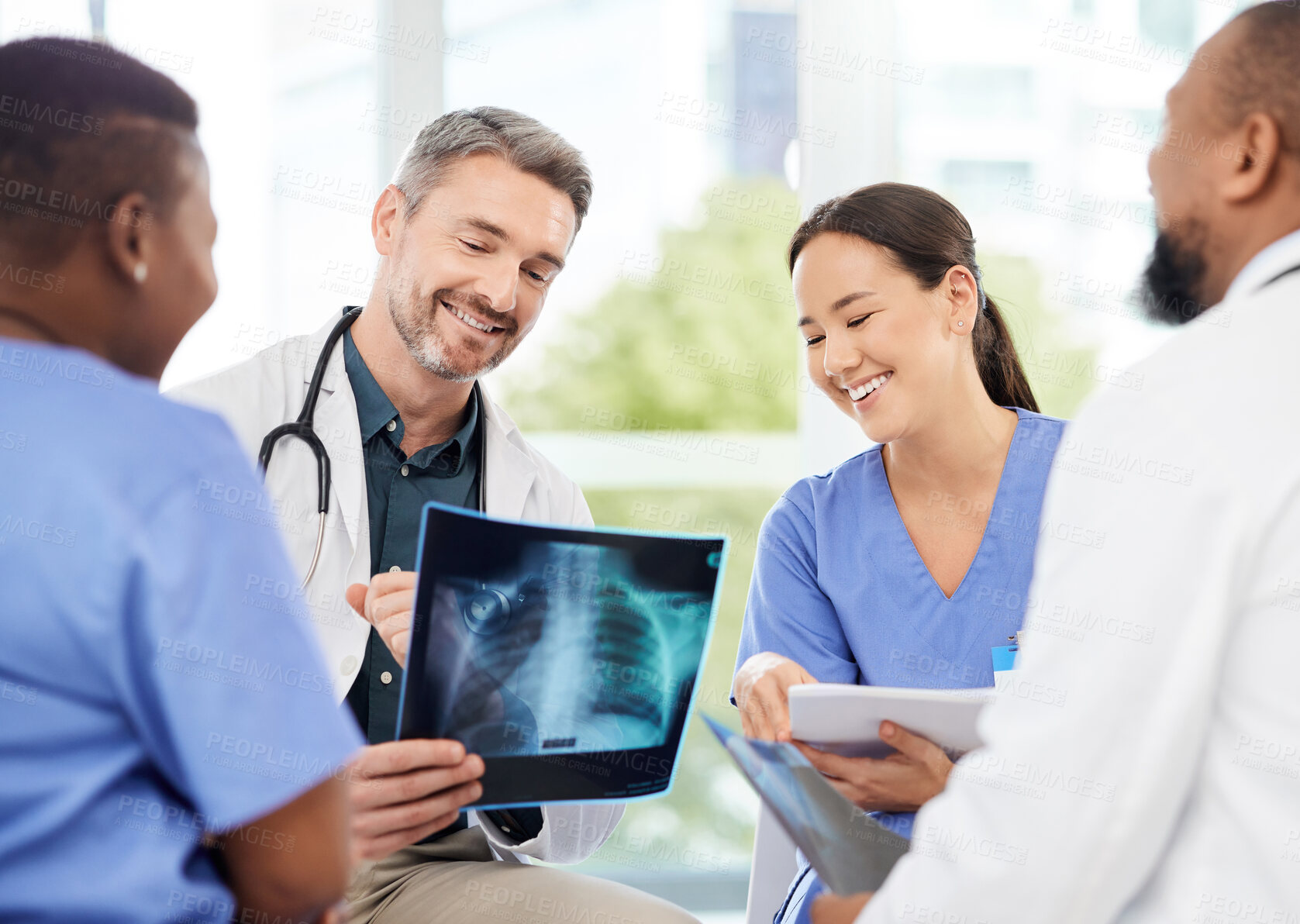 Buy stock photo Shot of a group of medical practitioners analysing x-rays in a hospital