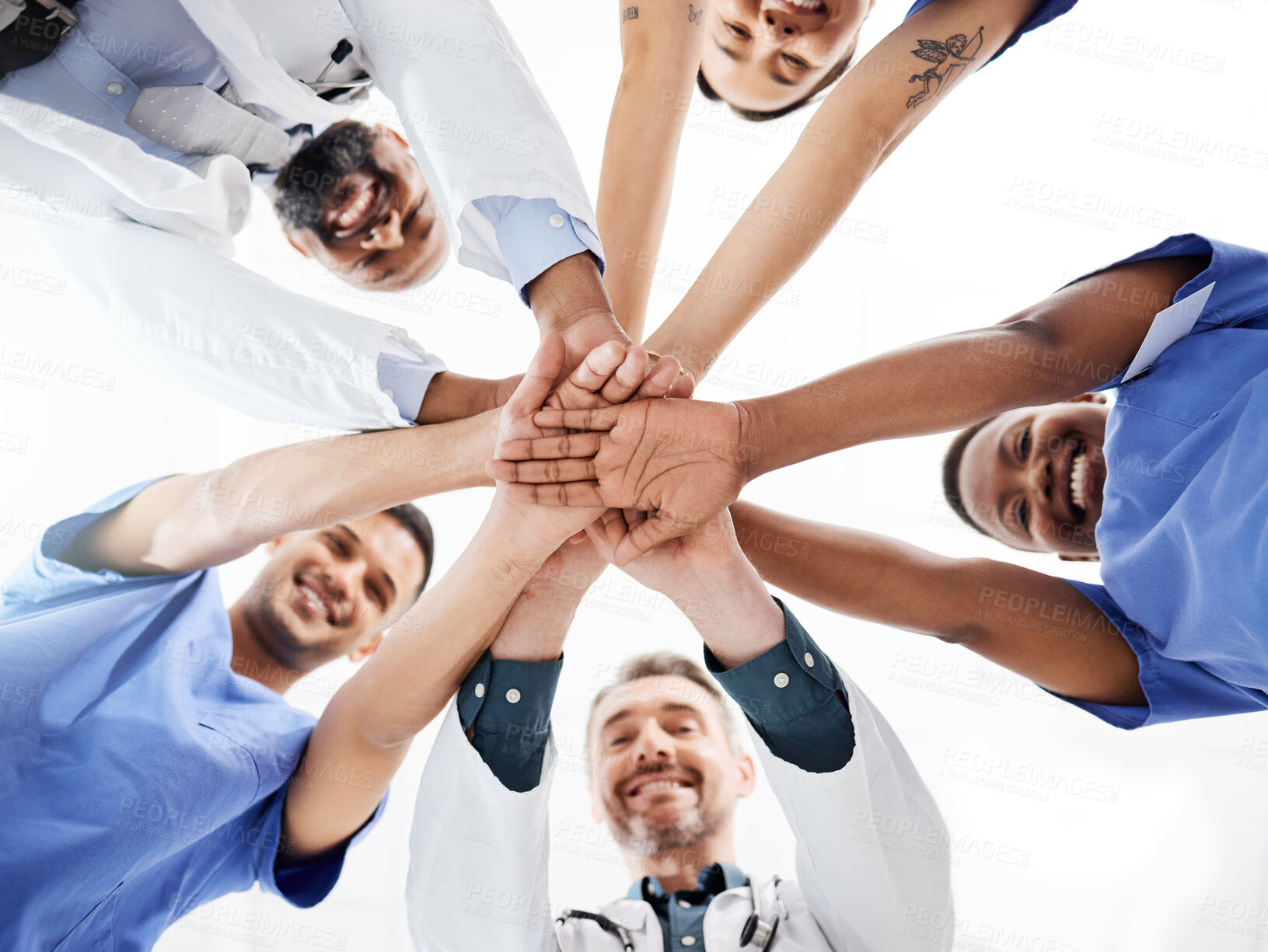Buy stock photo Shot of a group of medical practitioners joining their hands together in a huddle