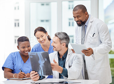 Buy stock photo Shot of a group of medical practitioners analysing x-rays in a hospital