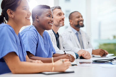 Buy stock photo Shot of a doctor sitting alongside his colleagues during a meeting in a hospital boardroom
