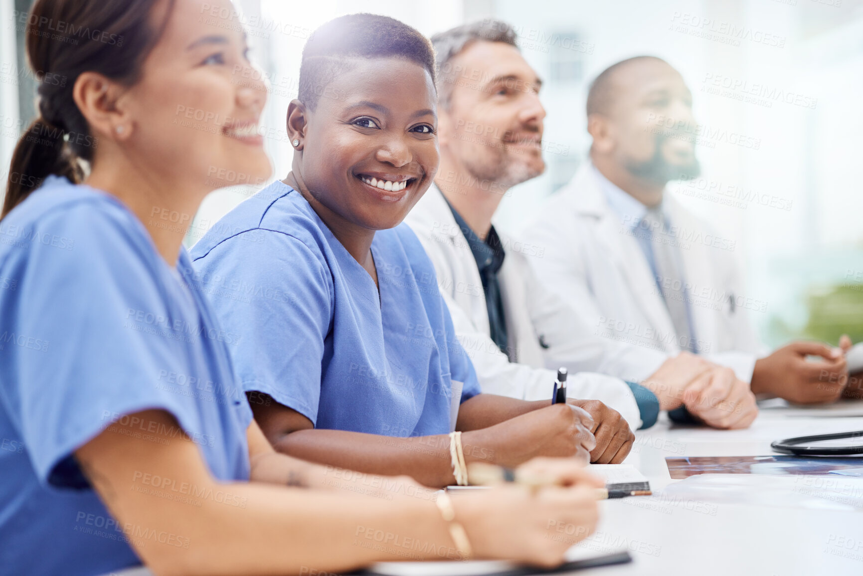Buy stock photo Shot of a doctor sitting alongside his colleagues during a meeting in a hospital boardroom