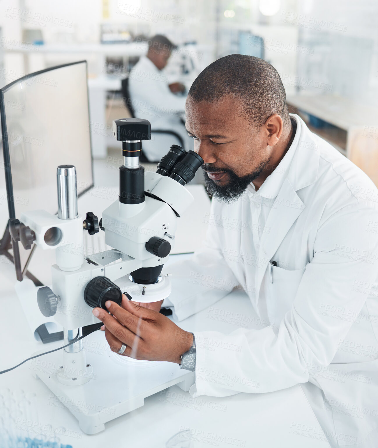 Buy stock photo Shot of a mature man using a microscope in a lab