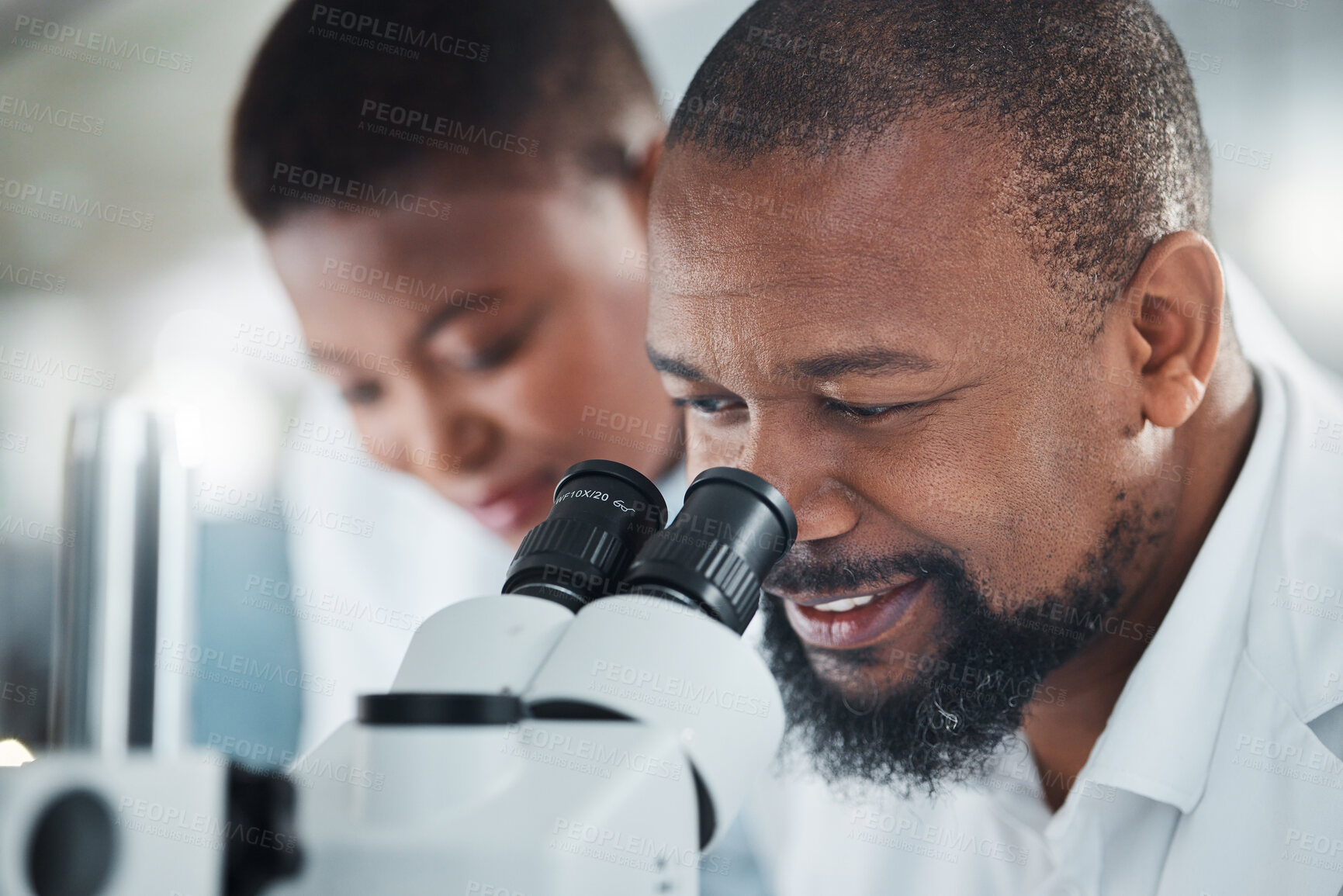 Buy stock photo Shot of a mature man using a microscope in a lab