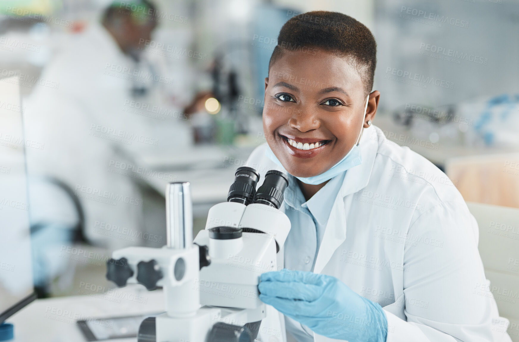 Buy stock photo Shot of a young woman using a microscope in a lab