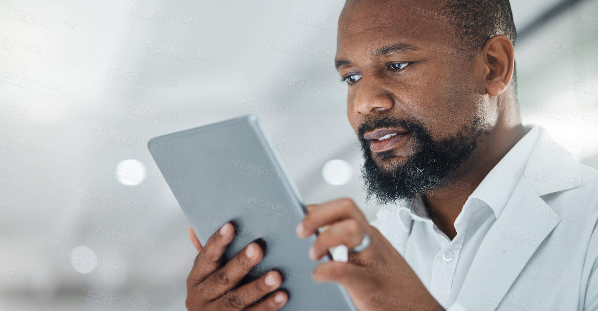 Buy stock photo Shot of a male scientist using a digital tablet while working in a lab