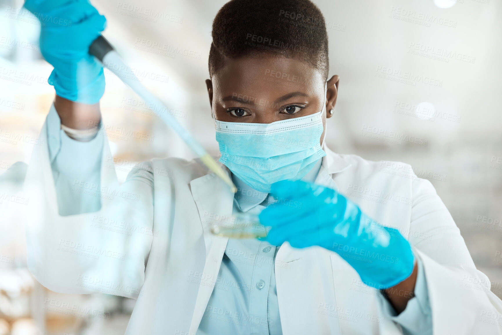 Buy stock photo Shot of a young scientist sitting alone in her laboratory and testing urine