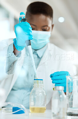 Buy stock photo Shot of a young scientist sitting alone in her laboratory and testing urine