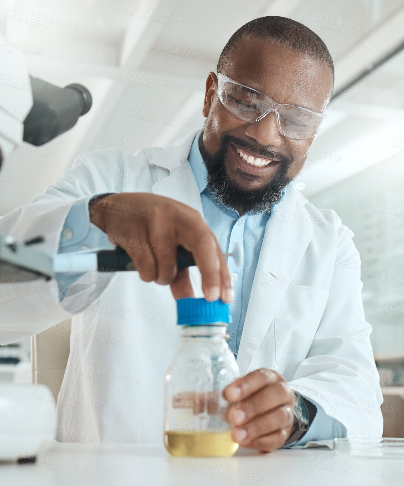 Buy stock photo Shot of a handsome mature scientist sitting alone in his laboratory and opening a bottle of liquid for testing
