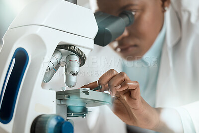 Buy stock photo Shot of an unrecognisable scientist using a microscope to analyse a sample in the laboratory