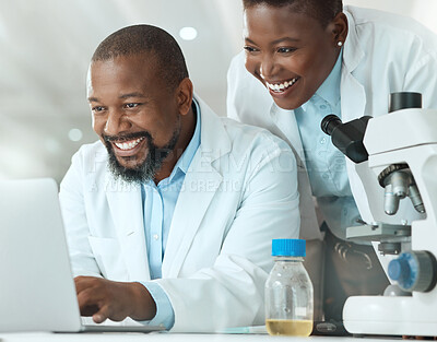 Buy stock photo Shot of two scientists using a laptop in a laboratory