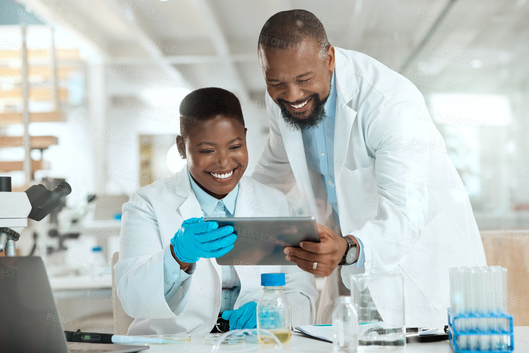 Buy stock photo Shot of two scientists using a digital tablet in a laboratory