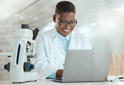 Buy stock photo Shot of an attractive young scientist sitting alone in her laboratory and using her laptop