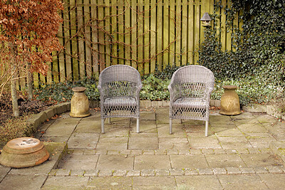 Buy stock photo Garden chairs, furniture and seating in a secluded and peaceful courtyard or home backyard. Handmade, craft and rustic wicker patio seats to relax, enjoy and meditate in zen and calm nature