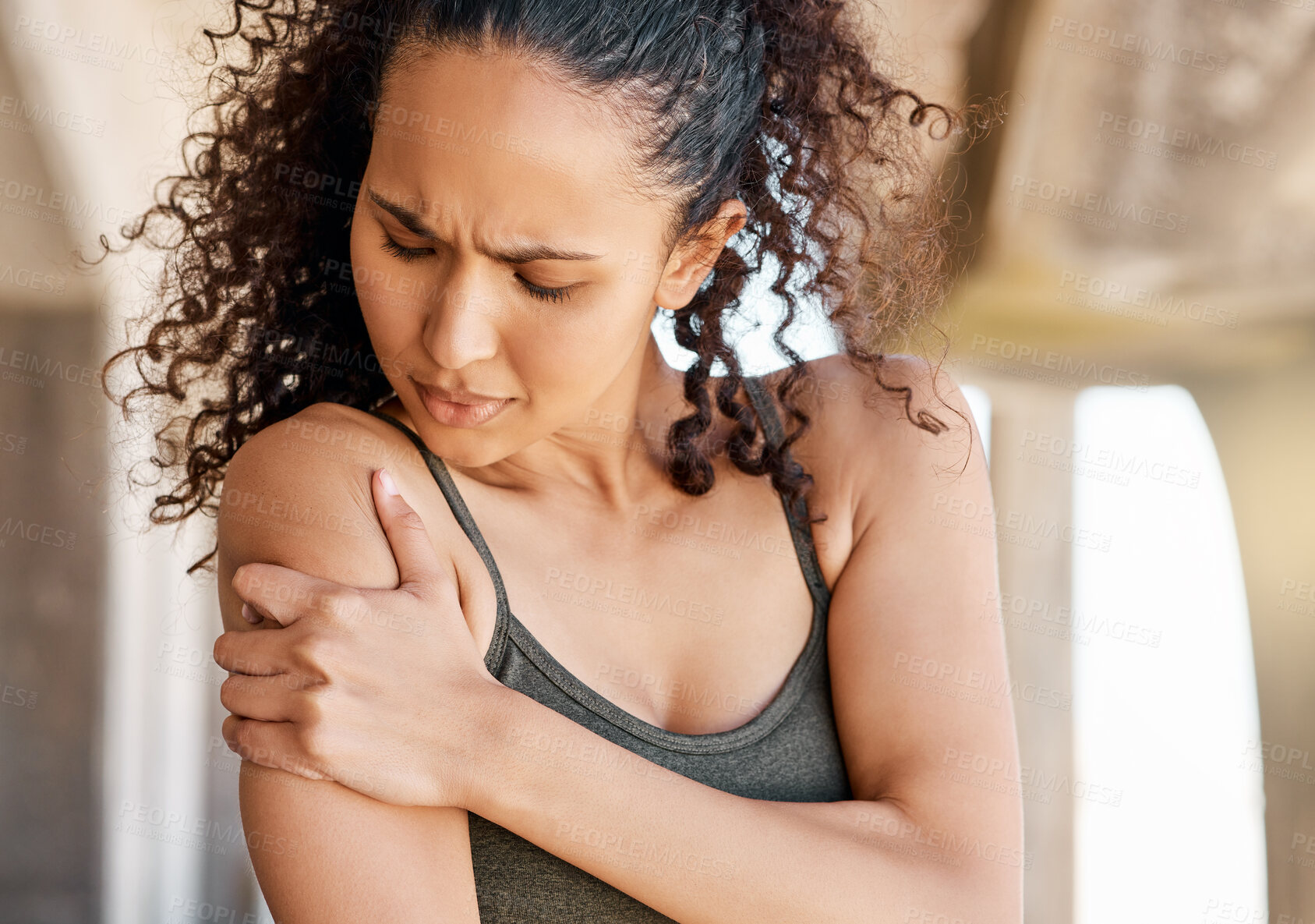 Buy stock photo Shot of an attractive young woman suffering from a shoulder injury during her outdoor workout