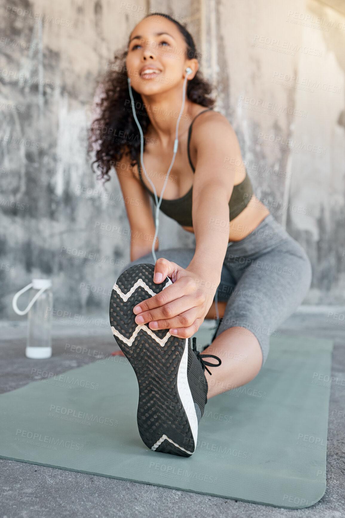 Buy stock photo Shot of a young woman stretching before her outdoor workout in the city