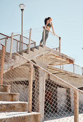 Buy stock photo Shot of a young woman standing alone in the city during her outdoor workout