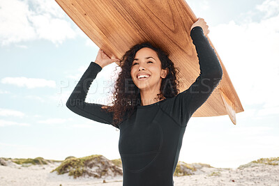 Buy stock photo Shot of an attractive young woman carrying a surfboard at the beach