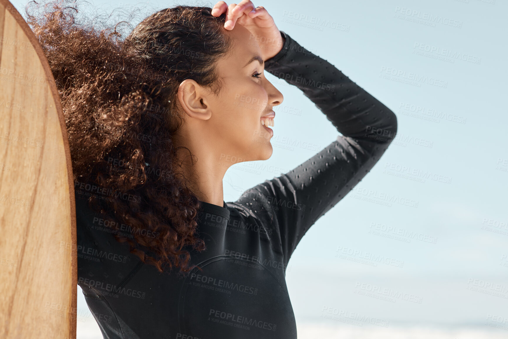 Buy stock photo Shot an attractive young woman posing with her surfboard and going out to surf at the beach