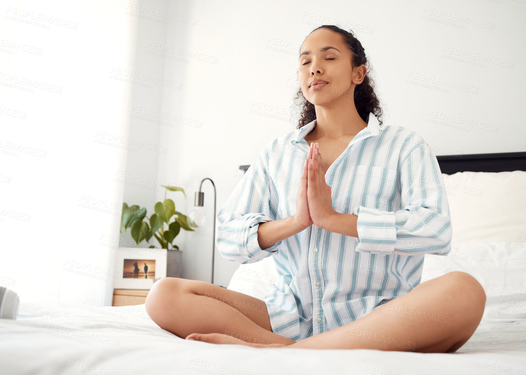 Buy stock photo shot of a young woman meditating at home