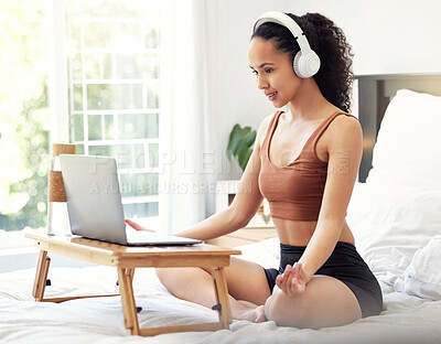 Buy stock photo Shot of a young woman meditating while using a laptop at home