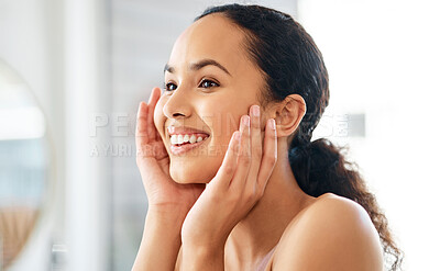 Buy stock photo Shot of a young woman admiring her skin in a bathroom at home