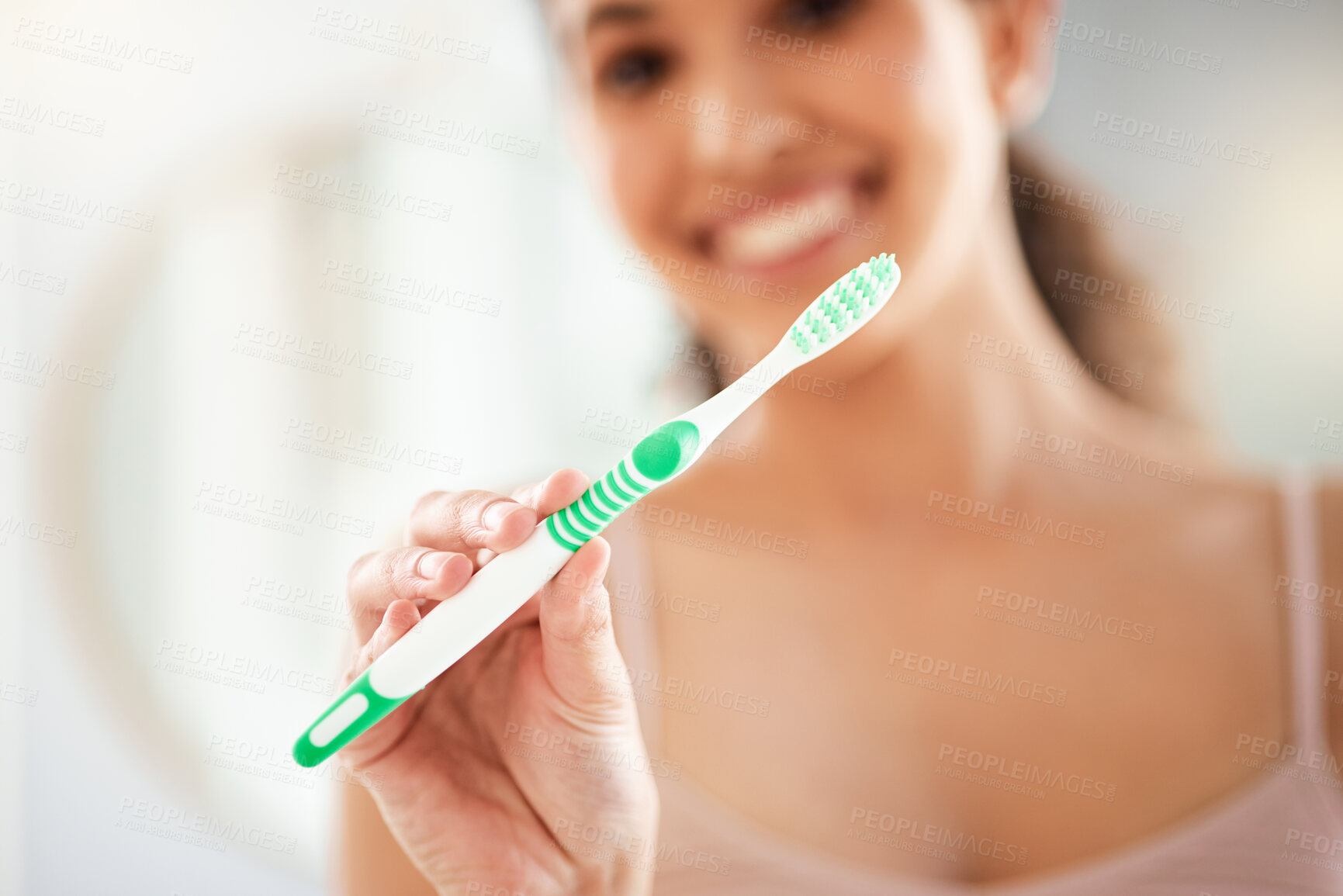 Buy stock photo Shot of a young woman brushing her teeth at home