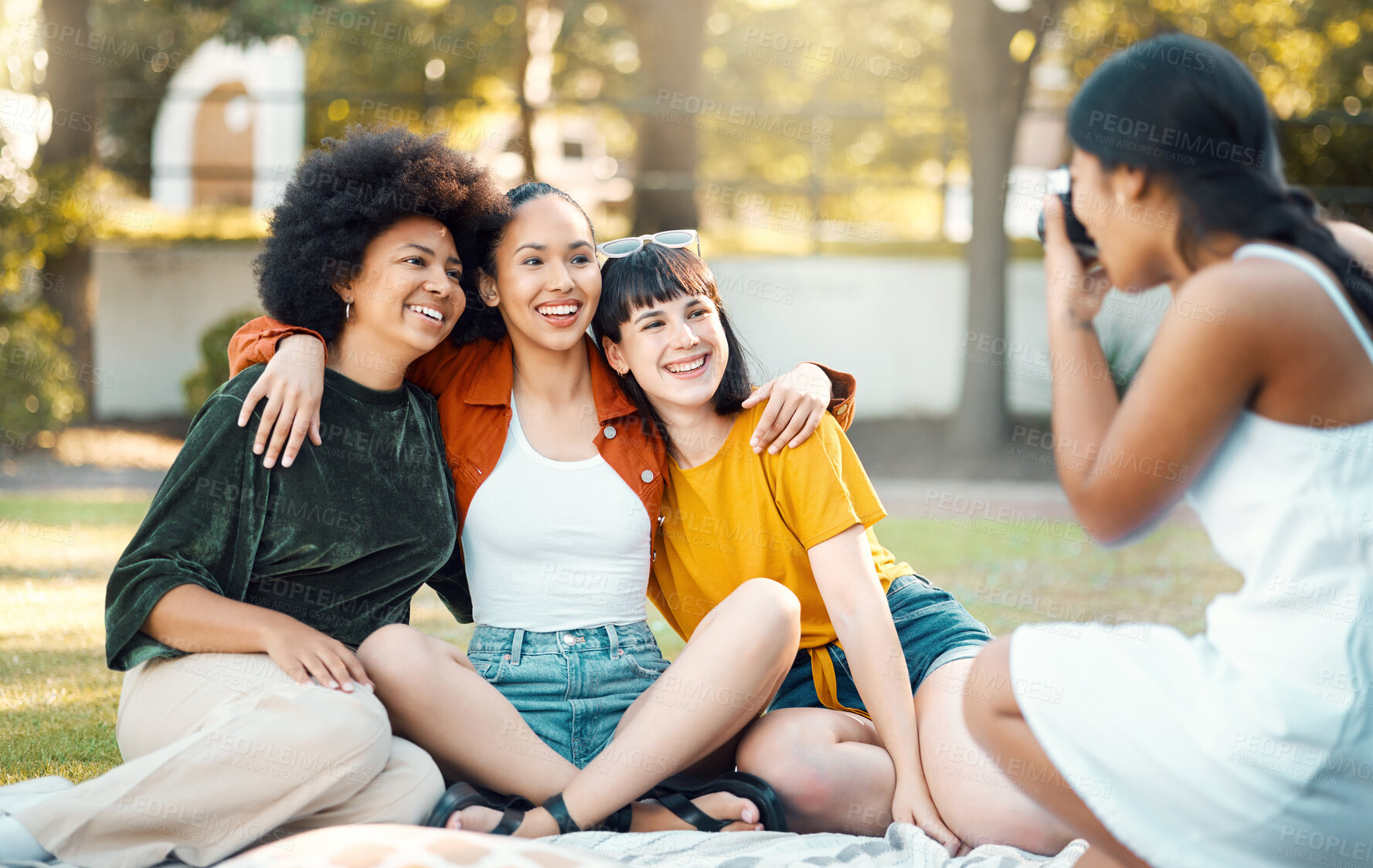 Buy stock photo Shot of a female taking photos of her friends in a park