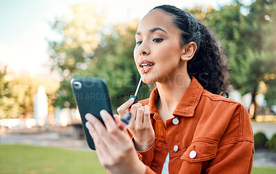 Buy stock photo Shot of a female applying makeup in a park