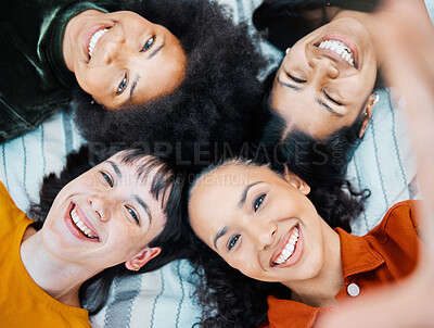 Buy stock photo Shot of female friends lying together on the blanket in a park