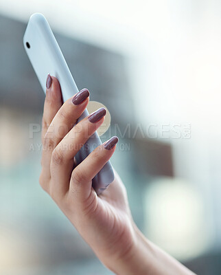 Buy stock photo Shot of a businesswoman using a smartphone against an urban background