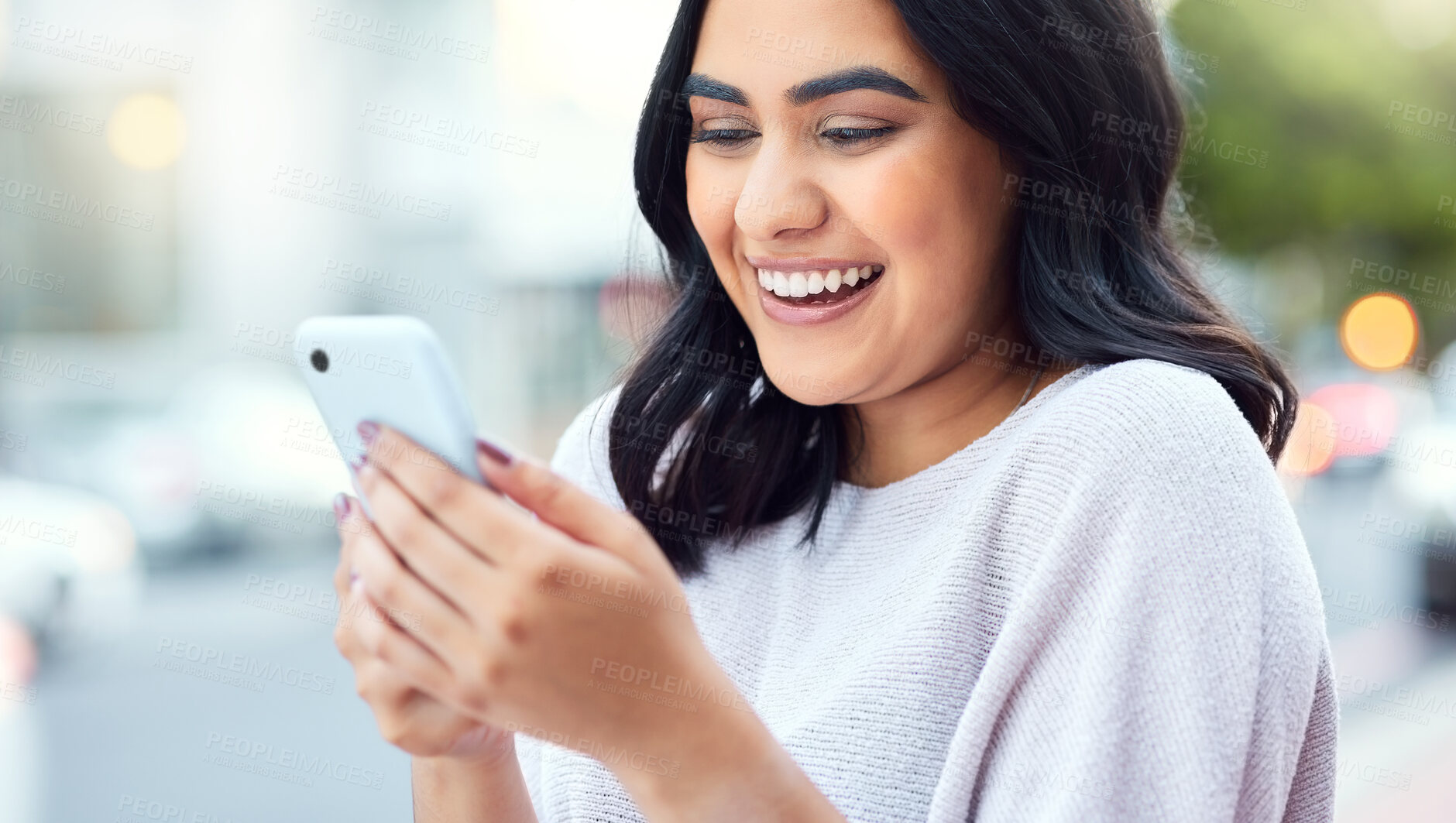 Buy stock photo Shot of a young businesswoman using a smartphone against an urban background