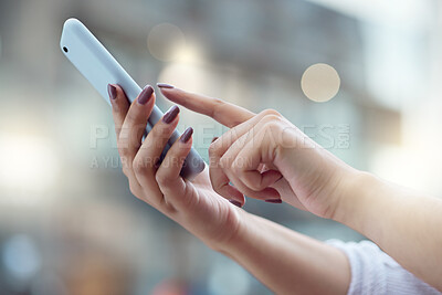 Buy stock photo Shot of a businesswoman using a smartphone against an urban background