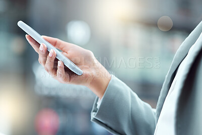 Buy stock photo Shot of a businesswoman using a smartphone against an urban background