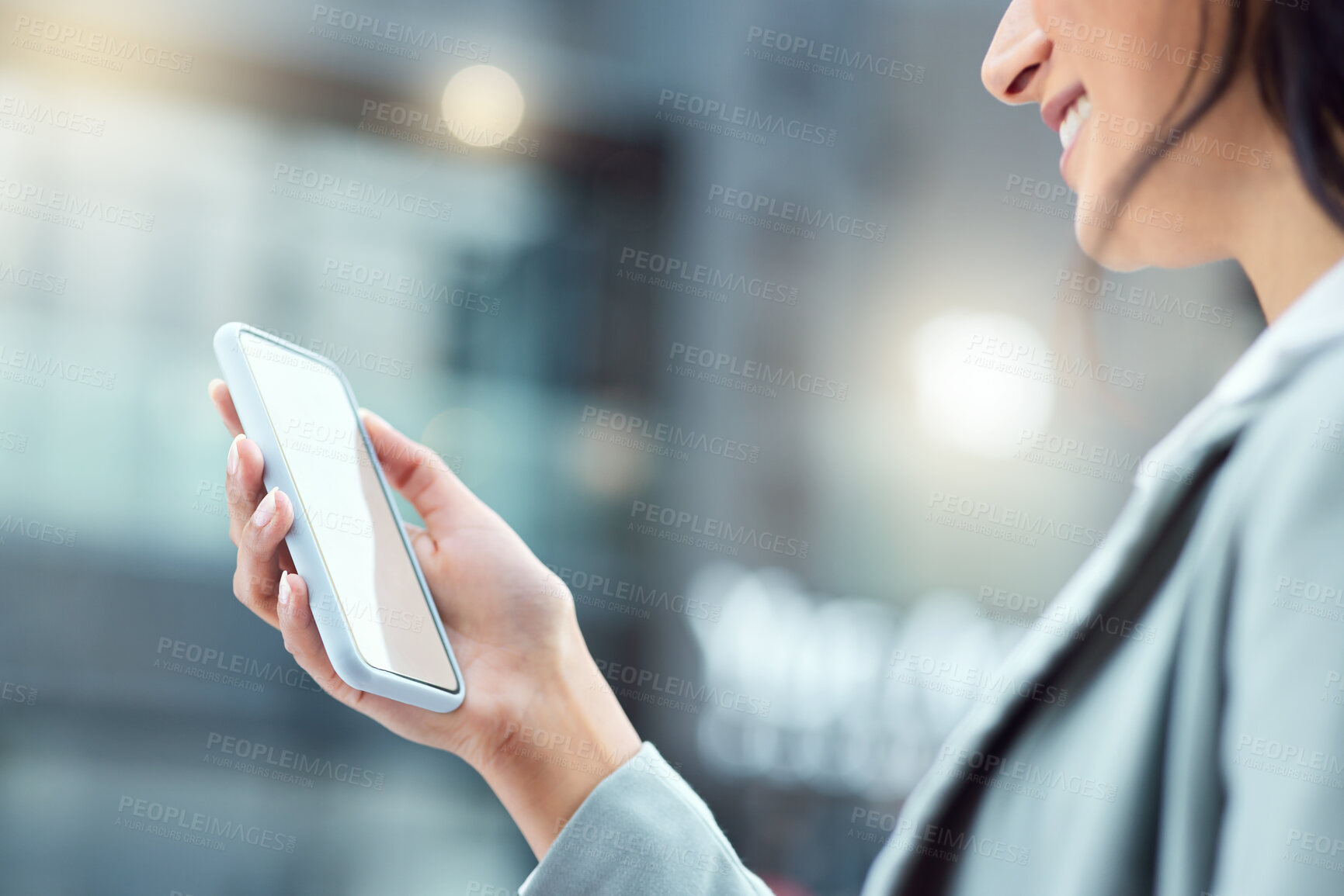 Buy stock photo Shot of a businesswoman using a smartphone against an urban background