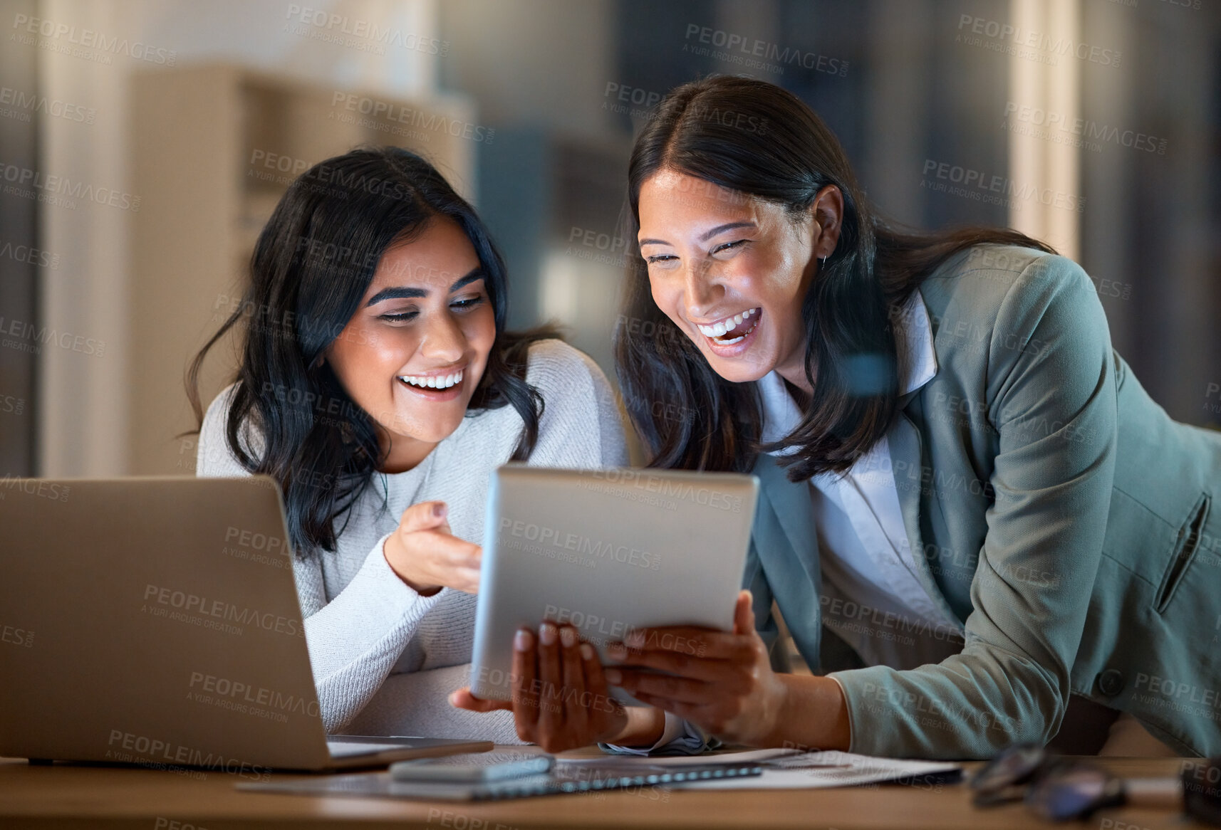 Buy stock photo Cropped shot of two attractive young businesswomen working late at their company offices