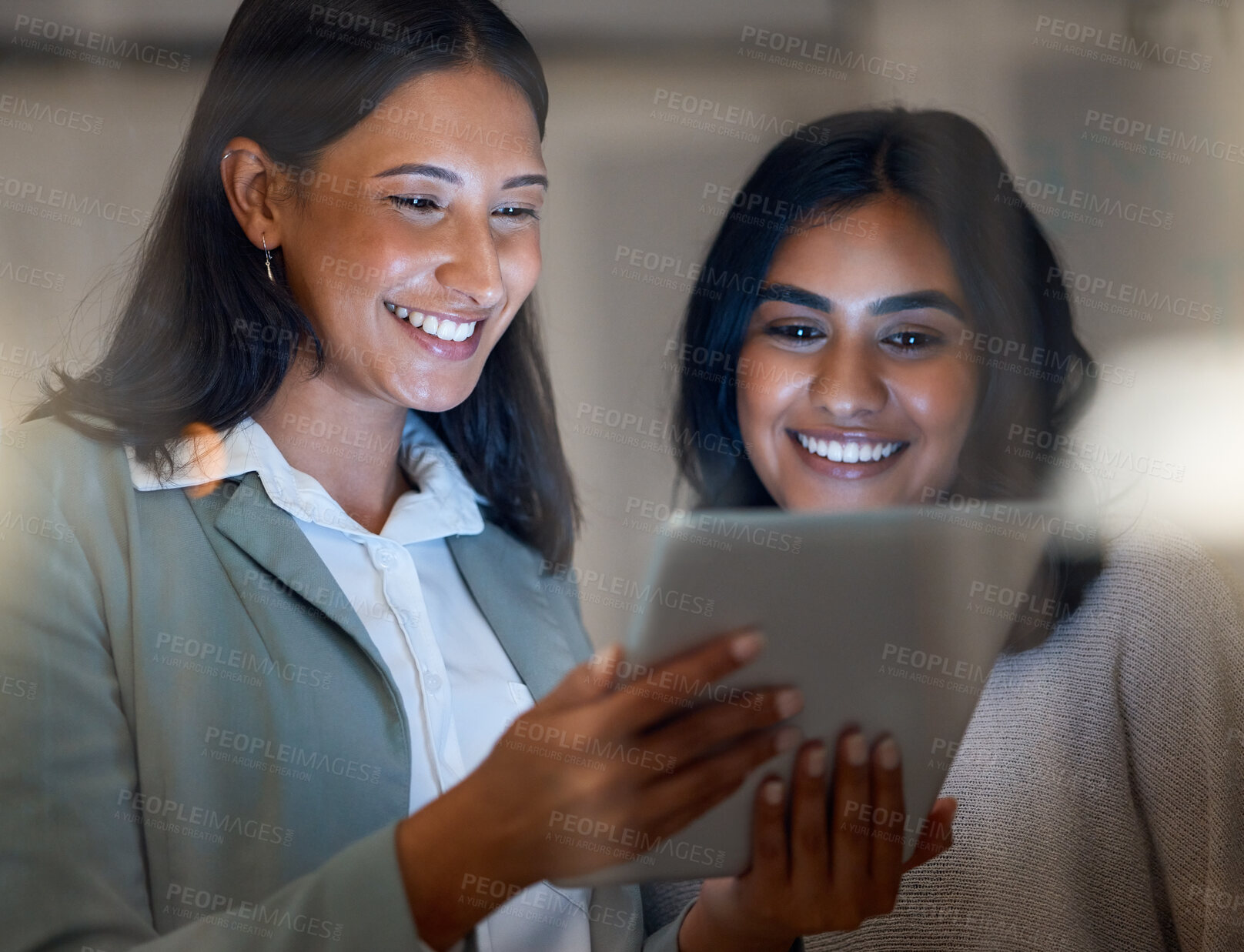 Buy stock photo Cropped shot of two attractive young businesswomen working late at their company offices